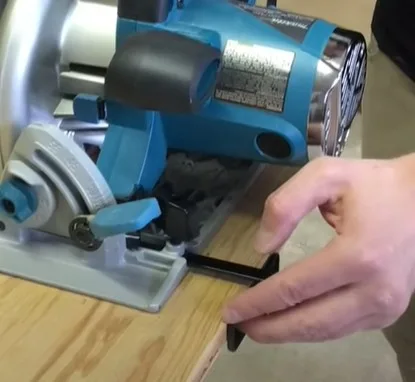 man using a rip fence with a circular saw