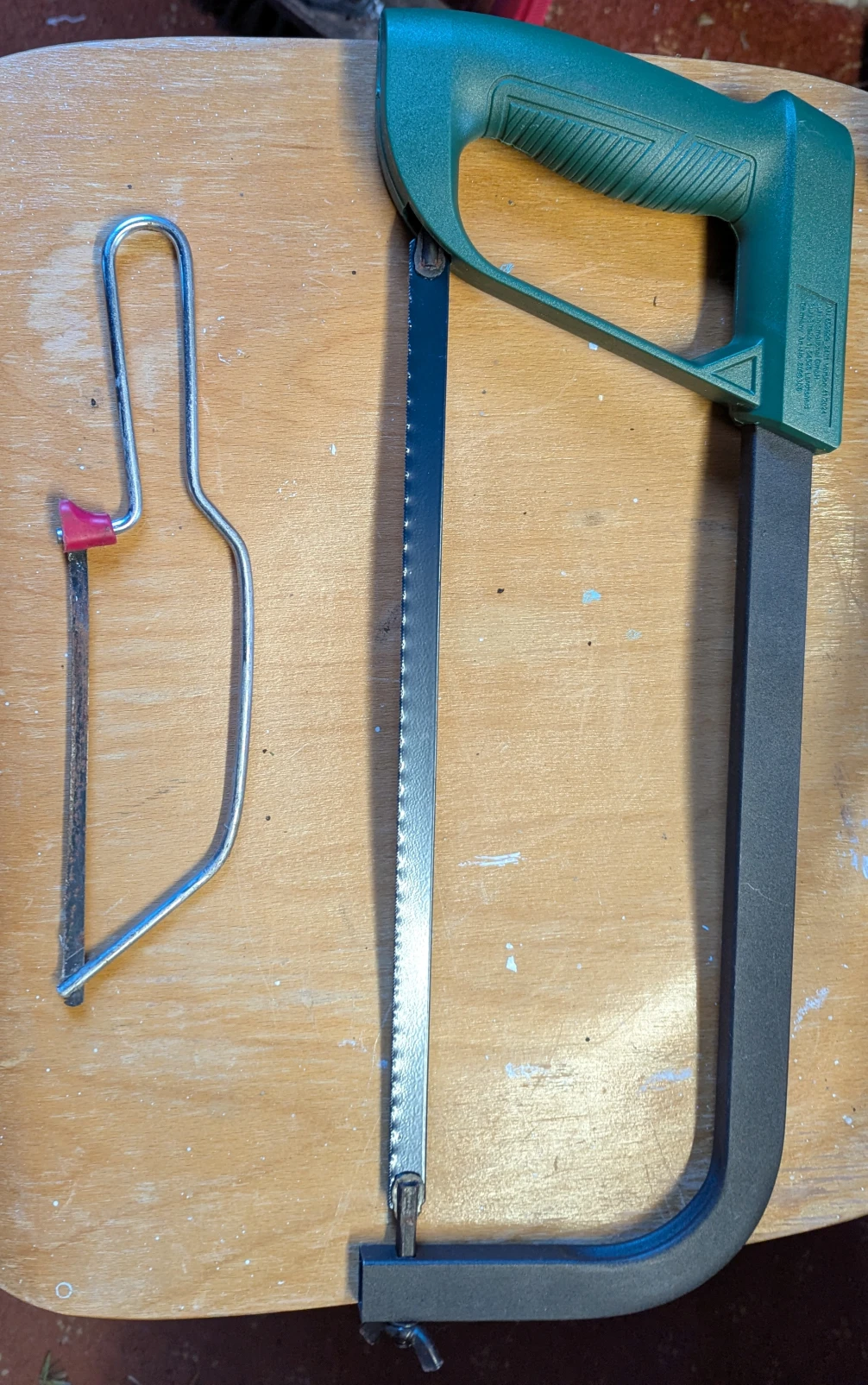 a junior hacksaw and a standard hacksaw side by side in my garage