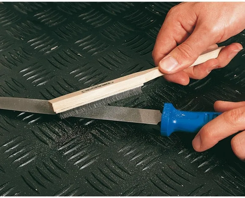 a file cleaning brush being used to clean a file